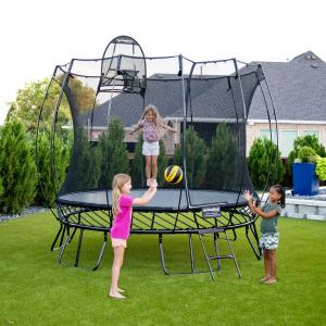 A girl jumping on a 10 ft round Springfree Trampoline while two other girls throw a ball outside of the trampoline.