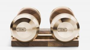 PENT x Swarovski luxury dumbbells crafted in champagne gold (PDV-X Coating) and walnut wood, featuring crystal-encrusted insets and displayed on a matching wooden stand — part of the Iron House collection of designer fitness equipment.