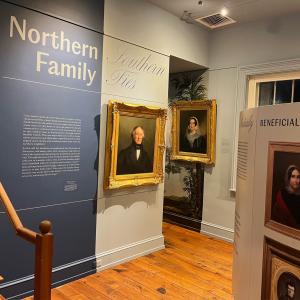 Gallery view of Morven Museum & Garden’s exhibition Northern Family, Southern Ties, featuring portraits in gold frames and interpretive wall text.