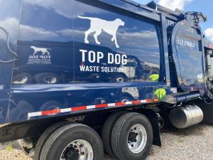 Close-up view of a Top Dog Waste Solutions truck positioned and ready for waste pickup