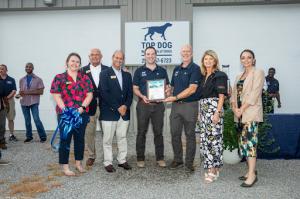 Top Dog Waste Solutions team displaying a recognition plaque honoring their strong commitment to commercial waste management excellence
