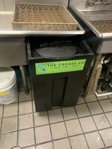 Commercial grease trap with The Grease Company logo, illustrating professional grease trap cleaning, grease removal, and FOG management.