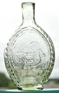 Historically important circa 1835-1840 American Eagle pale vaseline color pint flask, depicting an eagle with a serpent in its beak (referred to as the “Snake of Corruption”) ($11,700).