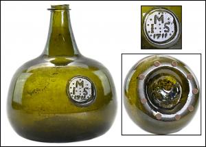 This British circa 1711 black glass onion form wine bottle (reading “M / I.S. / 1711” on an applied seal), deep yellowish olive green in color, found a new owner for $4,095.
