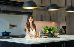 Ariana Adireh Anderson in a luxury custom kitchen designed by Ariana Designs & Interiors, showcasing personalized interior design with modern elegance.