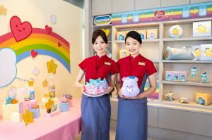 Two China Airlines flight attendants in red and blue uniforms present themed snacks and plush toys from the WooTEA × Care Bears™ “Cloud Party” collaboration, surrounded by colorful rainbow and star decorations.