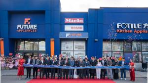 A group of executives and guests stand in front of the Future Appliances store for a ribbon-cutting ceremony, with confetti and floral arrangements celebrating the grand opening.
