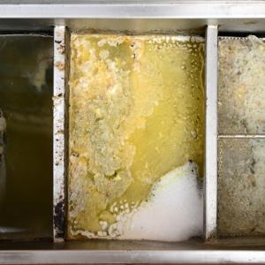 Close-up of a full grease trap, highlighting the importance of timely grease trap cleaning, grease removal, and grease pumping to avoid sewer backups.