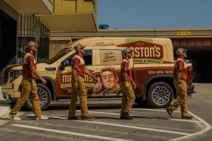 Maston's team members walking in front of branded vehicle.