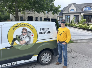 Mosquito Man technician standing beside branded pest control service van in Windsor, Ontario, ready for mosquito treatment.