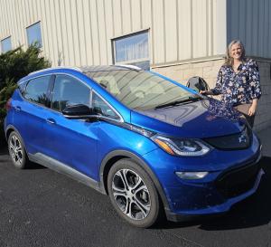 Rhoda Miller charging her electric car from solar power collected from the roof of the warehouse