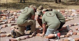 A group of veterans are kneeling in the center of a labyrinth.