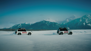 Mongolia tour lead through stunning landscapes. In this picture two Avis 4x4 Mongolia rental cars drive through a winter landscape, with mountains in the background.