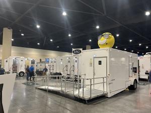 Restroom trailers with accessibility ramps on display at the PSAI Convention in Daytona Beach, Florida, where Rooter Man SC attended to learn about sanitation innovations.