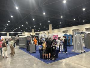 Crowds visiting exhibitor booths and portable restroom displays at the PSAI Convention and Trade Show in Daytona Beach, Florida.