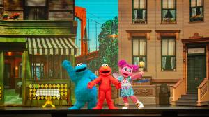 Sesame Street characters performing on stage, showcasing a vibrant and lively atmosphere.