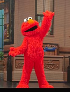 Sesame Street's Elmo entertains on stage, showcasing a colorful and energetic performance for viewers.
