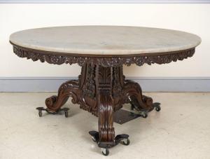 19th century carved teak Anglo-Indian pedestal table with floral carved apron, pedestal with carved volutes and acanthus, and a white marble top. Estimate: $5,000-$8,000.