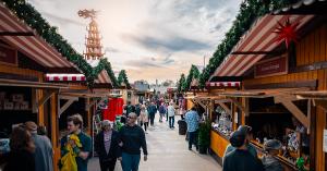 Christkindlmarkt Visitors shop and talk with vendors down a cozy market alley.