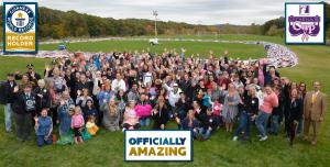 Volunteers gather and pose with the worlds longest bra-chain in the background.