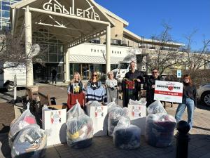 Staff from YogaSix South Hills, Club Pilates South Hills, StretchLab Mt. Lebanon, and Children’s Museum of Pittsburgh smiling and holding collected sweaters for the 2024 Mister Rogers’ Neighborhood Sweater Drive.