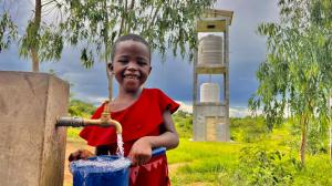 Child in Malawi drinks clean water from a tap - powered by a solar water system of Innovation: Africa