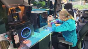 A technician from Durable Dental Lab performs same-day dental restoration work inside the mobile dental lab unit.