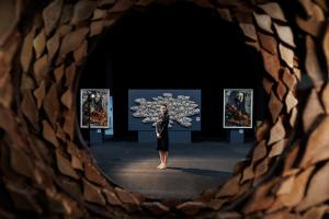 امرأة في مركز دائرة فنية داخل معرض تابع لمنتدى المرأة المبدعة 2025.