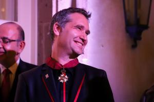 Bram Govaerts smiling while wearing the Commander of the Order of the Crown medal during the ceremony in Mexico City