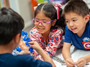 Kids Holding Parts of a Robot as They Learn to Create Code