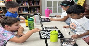 Kindergarten students enjoying a game of chess.