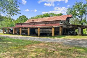 a 55.76 +/- acre parcel and a 17.71 +/- acre parcel offered individually and in the entirety of 73.47 +/- acres with a barndominium shell, chapel, country store and several other outbuildings/shop, 2 wells and 3 septic systems (one rated for 25 room hotel)