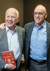 a photo of authors Bob Levin and Kevin Goetz holding their book, How to Score in Hollywood