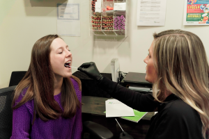 Medical staff using a cheek swab DNA test on a patient