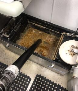 Grease trap pumping in progress, with Inland Empire Grease Company technicians removing accumulated grease and wastewater from a kitchen trap.