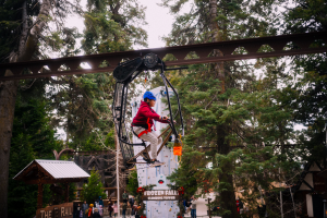 Child riding the B-Rail, a bike suspended from the monorail up to 45' above the Village.