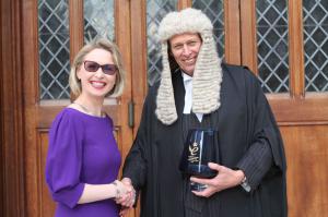 Photograph of Guildhawk CEO & Founder Jurga Zilinskiene MBE dressed in purple outside London Guildhall receiving The Queens' Award for International Trade Trophy from Paul Double The City Remembrancer wearing traditional ceremonial wig and gown
