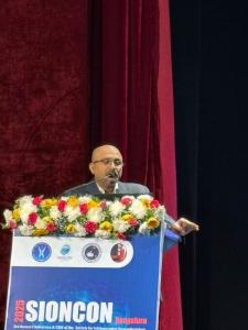 Dr. Mohana Rao Patibandla speaking at the podium during SIONCON 2025 in Bengaluru, delivering insights on intraoperative neuromonitoring as part of his expert lecture.