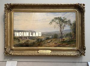 Photo of Never Forget (2021) by Nicholas Galanin. A text reads Indianland placed digitally on top of Valley of Wyoming (1865) by Jasper Francis Cropsey