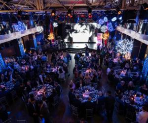 A photo of British Bash attendees seated in a festive holiday setting at Edison Ballroom