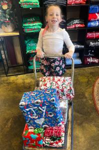 small child pushing gifts on a cart