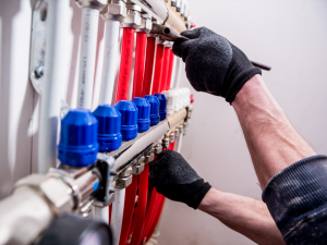 man fixing underfloor heating maintenance manifold