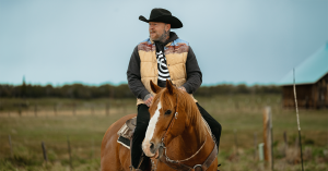 Pro skateboarder Jason Ellis rides a horse in Utah while wearing a cowboy hat.