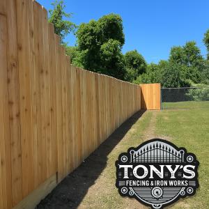 Cedar wood fence with reddish-brown panels and clean black hardware built by Tony’s Fencing and Iron Works in Covington, Louisiana.