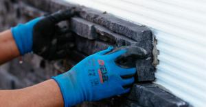 Installer attaching stone veneer to the Stone Panel+ continuous insulation panel, which provides R-value, moisture management, and a simplified installation process.