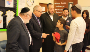 Dr. Joshua Weinstein (left), Assemblyman Steven Cymbrowitz (middle), Mr. Ezra Friedlander (right) greeting students at SKHOV