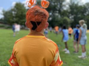 A teen camper shows off team spirit, including a painted YMCA logo in his hair, as he cheers for his team at the annual YGBW Teen Titan Showdown.