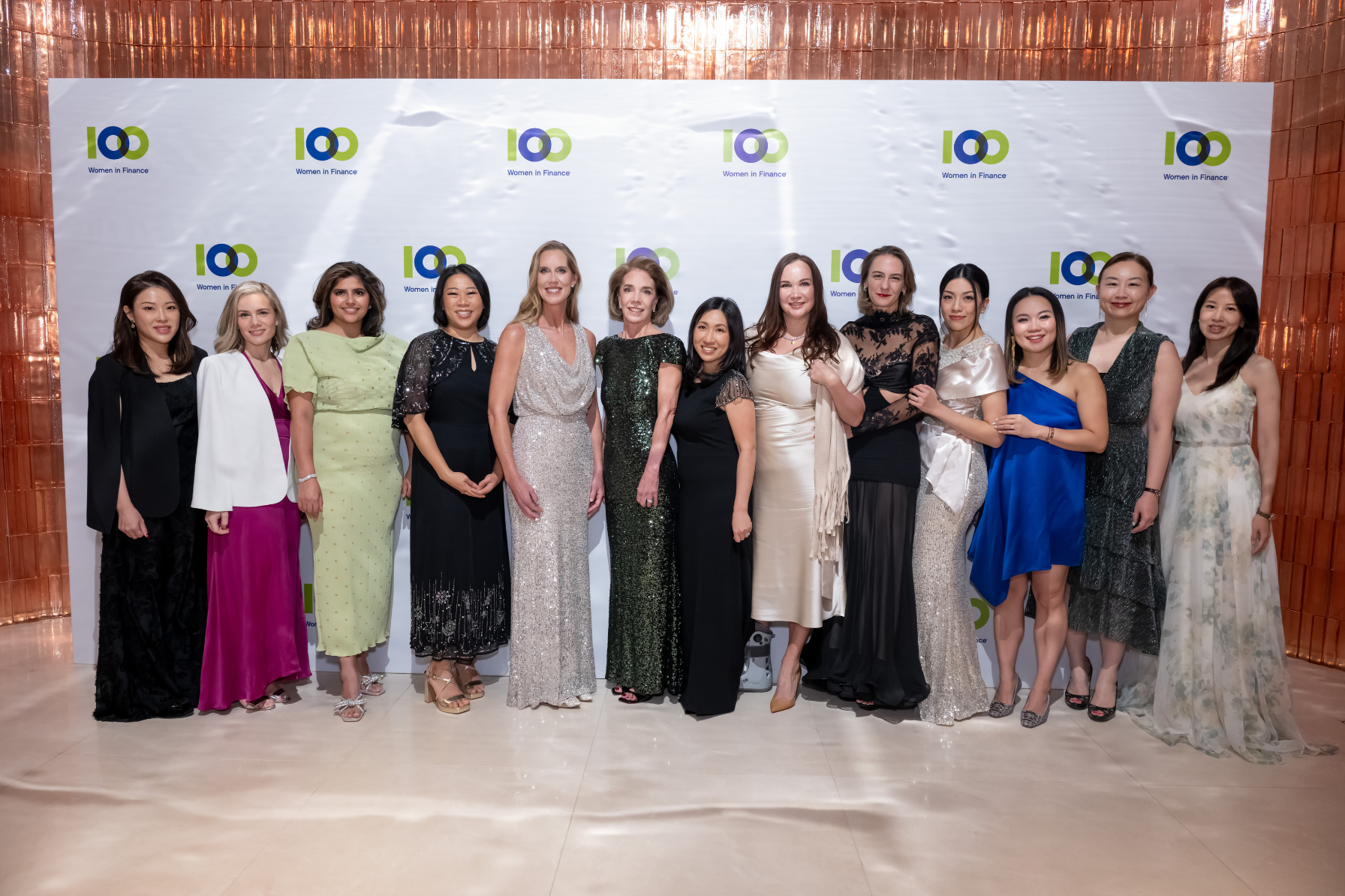Group photo of Lisa Johnson, Kellan Brown, and 100 Women in Finance members standing in front of a 100WF step-and-repeat at the Hong Kong Gala.