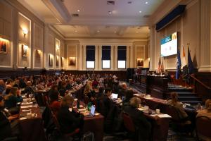 A large room at the New York Bar Association filled with conference delegates listening to a discussion between two men on the podium at the 12th Annual Advanced Forum on False Claims and Qui Tam Enforcement